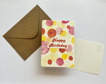 Carte d'anniversaire aquarelle avec motifs colorés et enveloppe kraft, idéale pour un cadeau festif