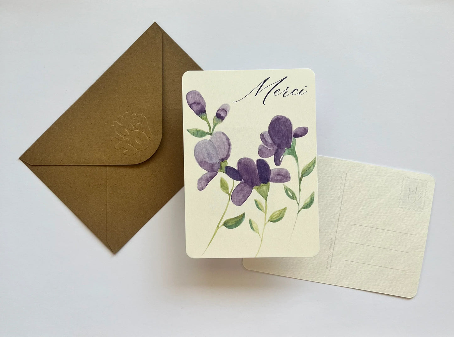 Carte de remerciement 'Merci' avec fleurs violettes aquarelle, enveloppe kraft, design élégant